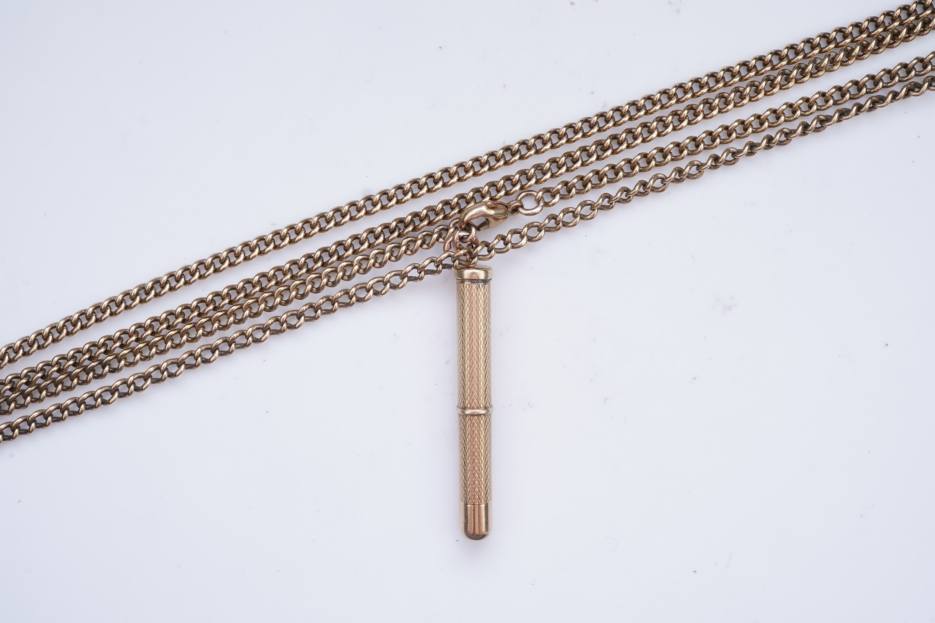 A gold toothpick and chain necklace